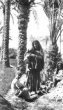 Žena s dítětem v náručí a další dvě děti pod  palmami, arabští kočovníci