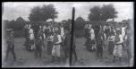 Dvojsnímek. Skupina lidí v tradičním národní kroji-šatu při slavnosti v neorganizovaném průvodu
